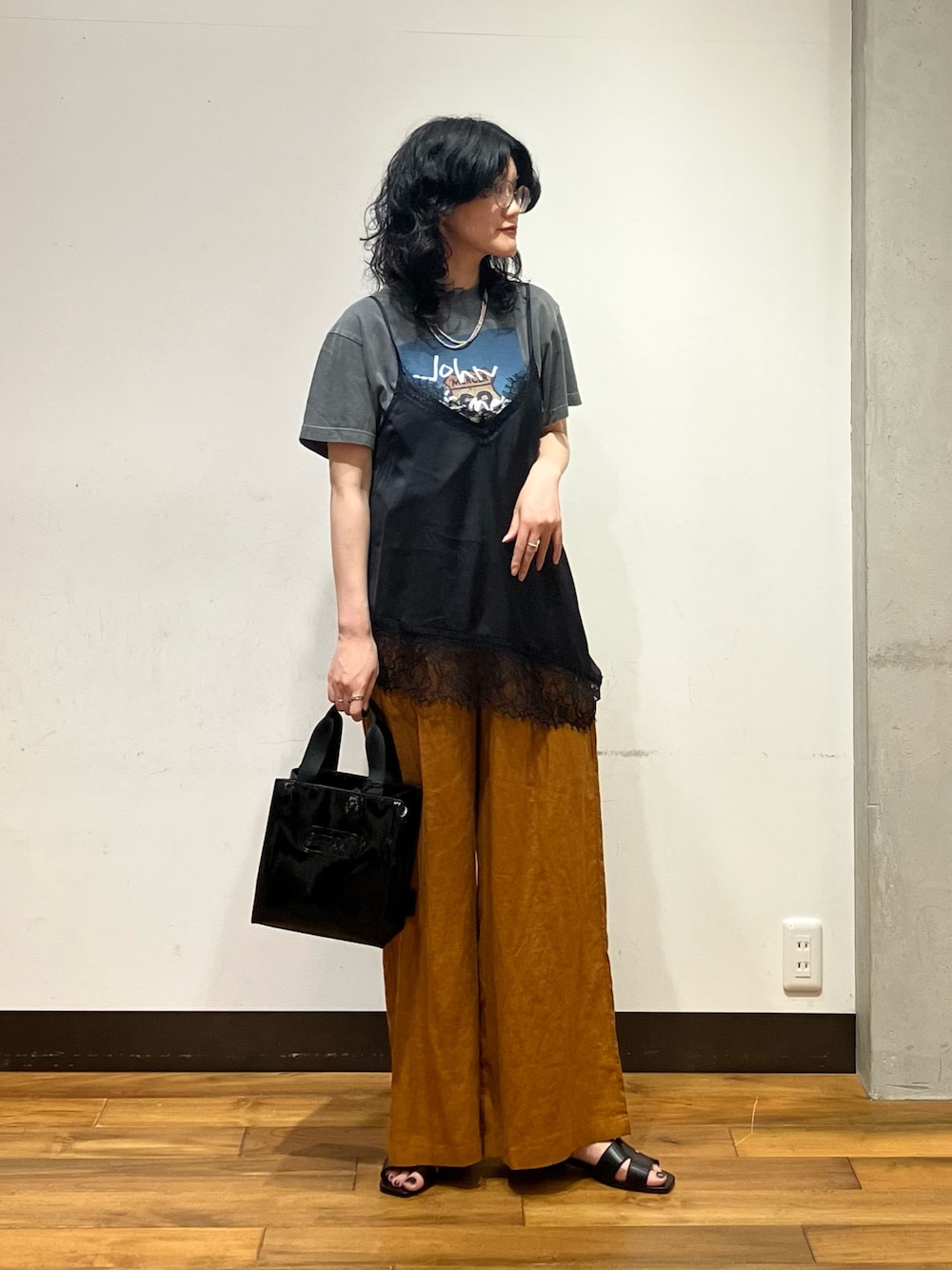 ブラウン系のその他パンツ、ブラック系のサンダル、ブラック系のショルダーバッグを着用したレディースの夏コーディネートの1枚目の写真