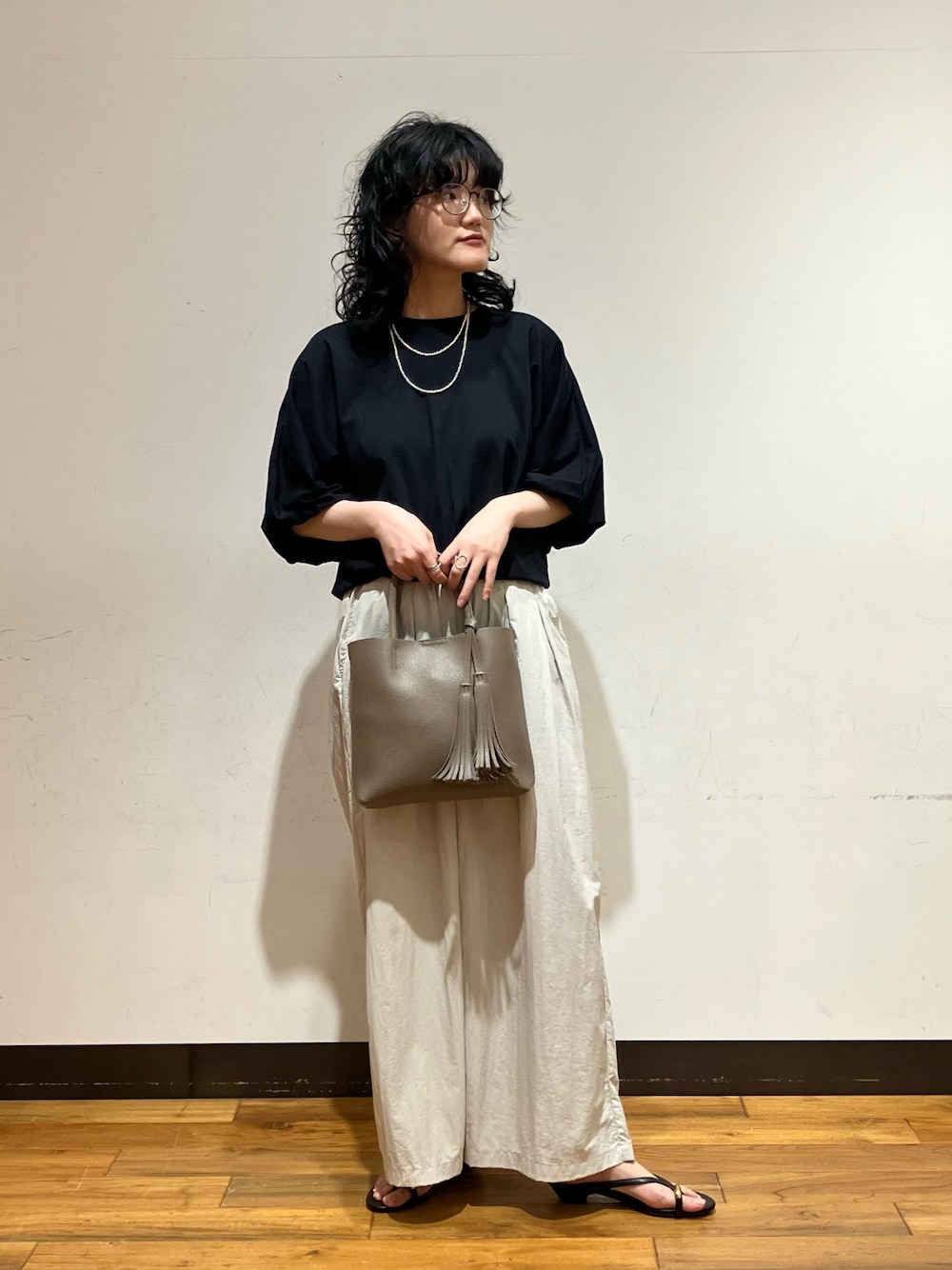 グレー系のその他パンツ、ブラック系のサンダル、グレー系のトートバッグを着用したレディースの春コーディネートの1枚目の写真