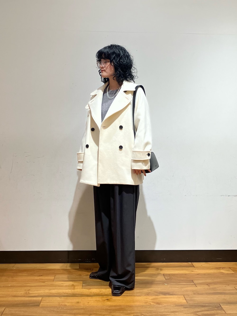 グレー系のその他パンツ、ブラック系のショルダーバッグ、ホワイト系のピーコートを着用したレディースの冬コーディネートの1枚目の写真