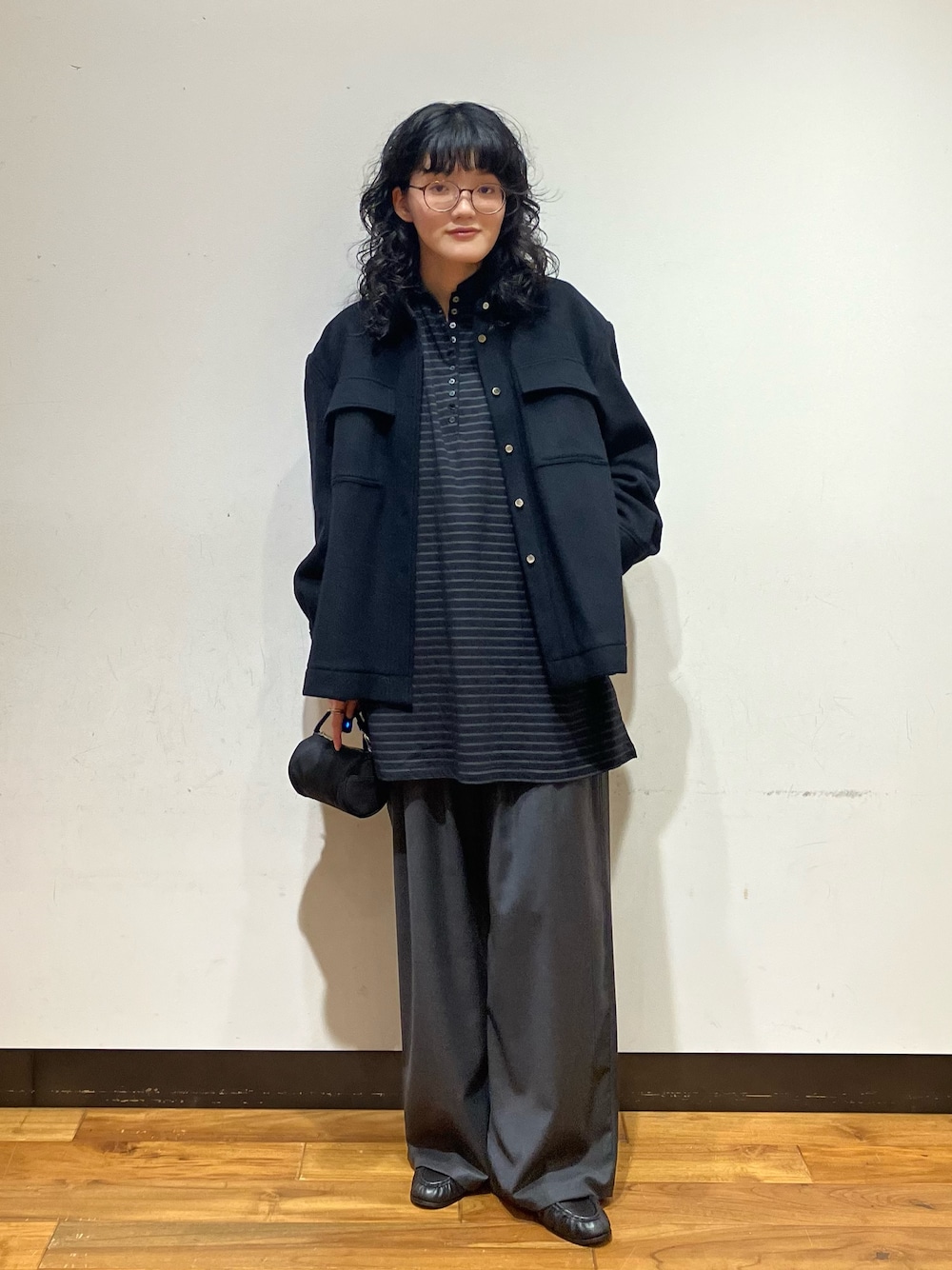 ブラック系のシャツ/ブラウス、グレー系のその他パンツ、ブラック系のハンドバッグを着用したレディースの秋コーディネートの1枚目の写真