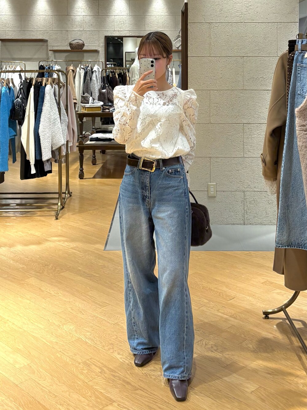 ホワイト系のシャツ/ブラウス、ブルー系のデニムパンツ、ブラウン系のブーツを着用したレディースの冬コーディネートの1枚目の写真