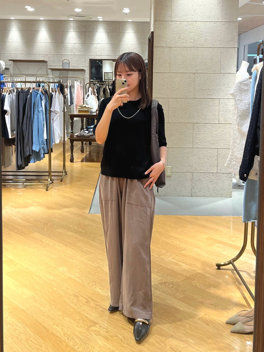 ブラック系のニット/セーター、ベージュ系のその他パンツ、ブラック系のその他シューズを着用したレディースの夏コーディネートの1枚目の写真