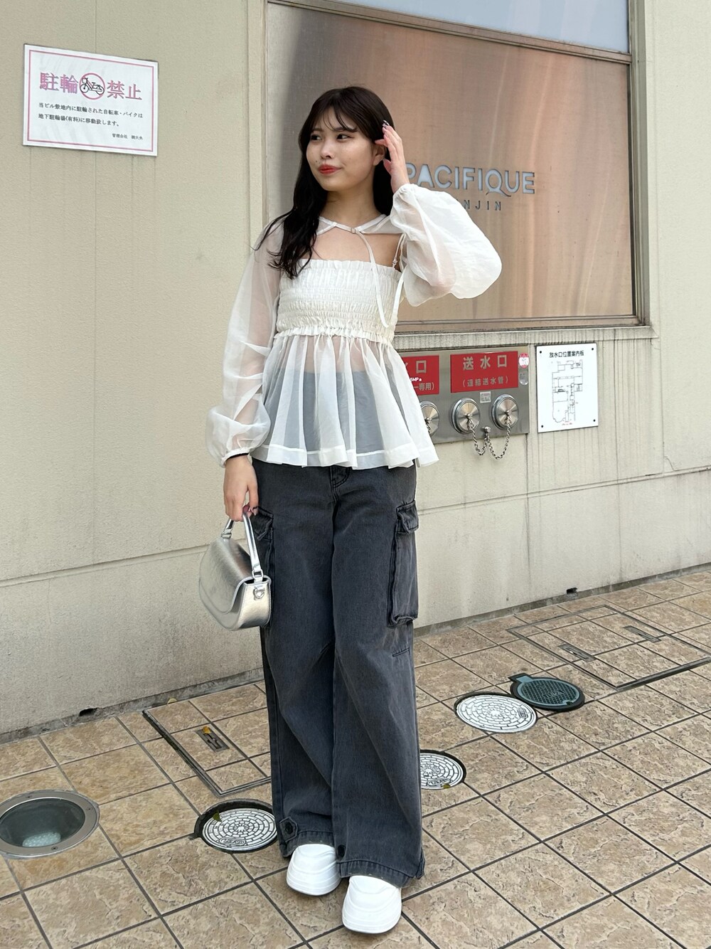 グレー系のデニムパンツ、ホワイト系のシャツ/ブラウス、ホワイト系のスニーカーを着用したレディースの春コーディネートの1枚目の写真