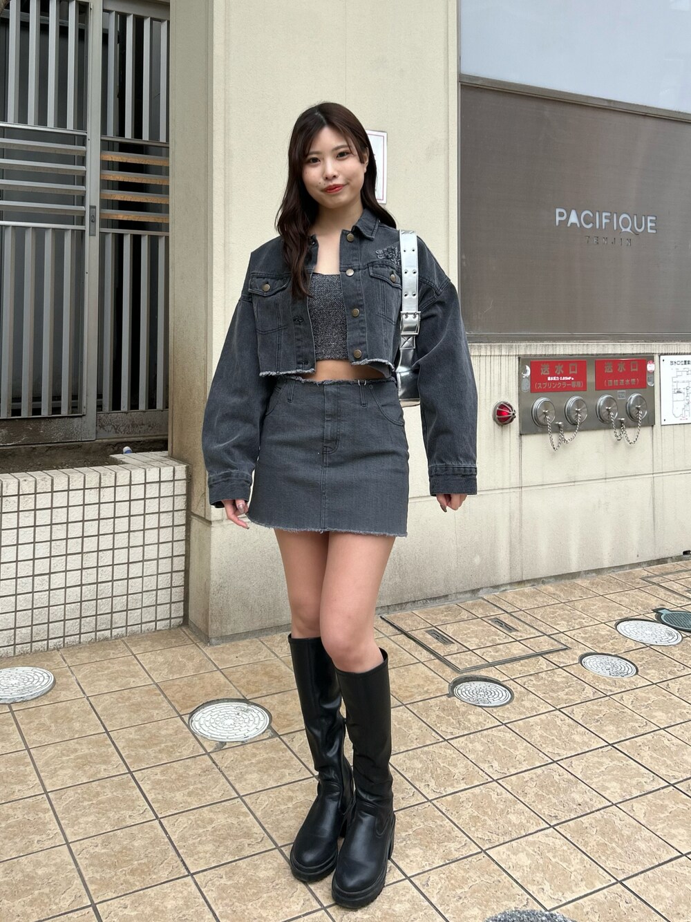 グレー系のデニムスカート、グレー系のデニムジャケット、ブラック系のブーツを着用したレディースの冬コーディネートの1枚目の写真