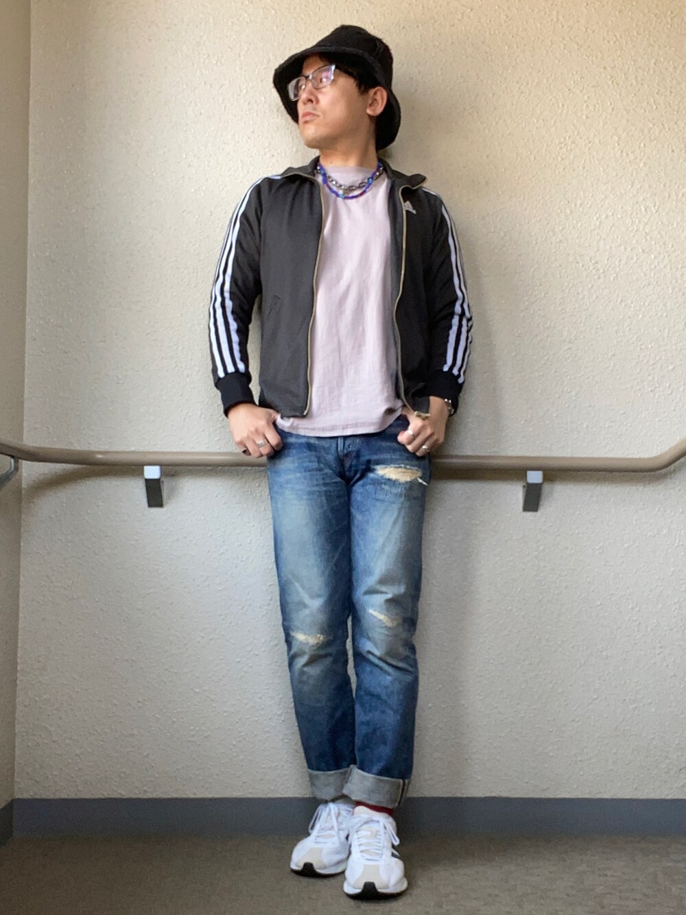 ブラック系のブルゾン、パープル系のTシャツ/カットソー、ブルー系のデニムパンツを着用したメンズの春コーディネートの1枚目の写真
