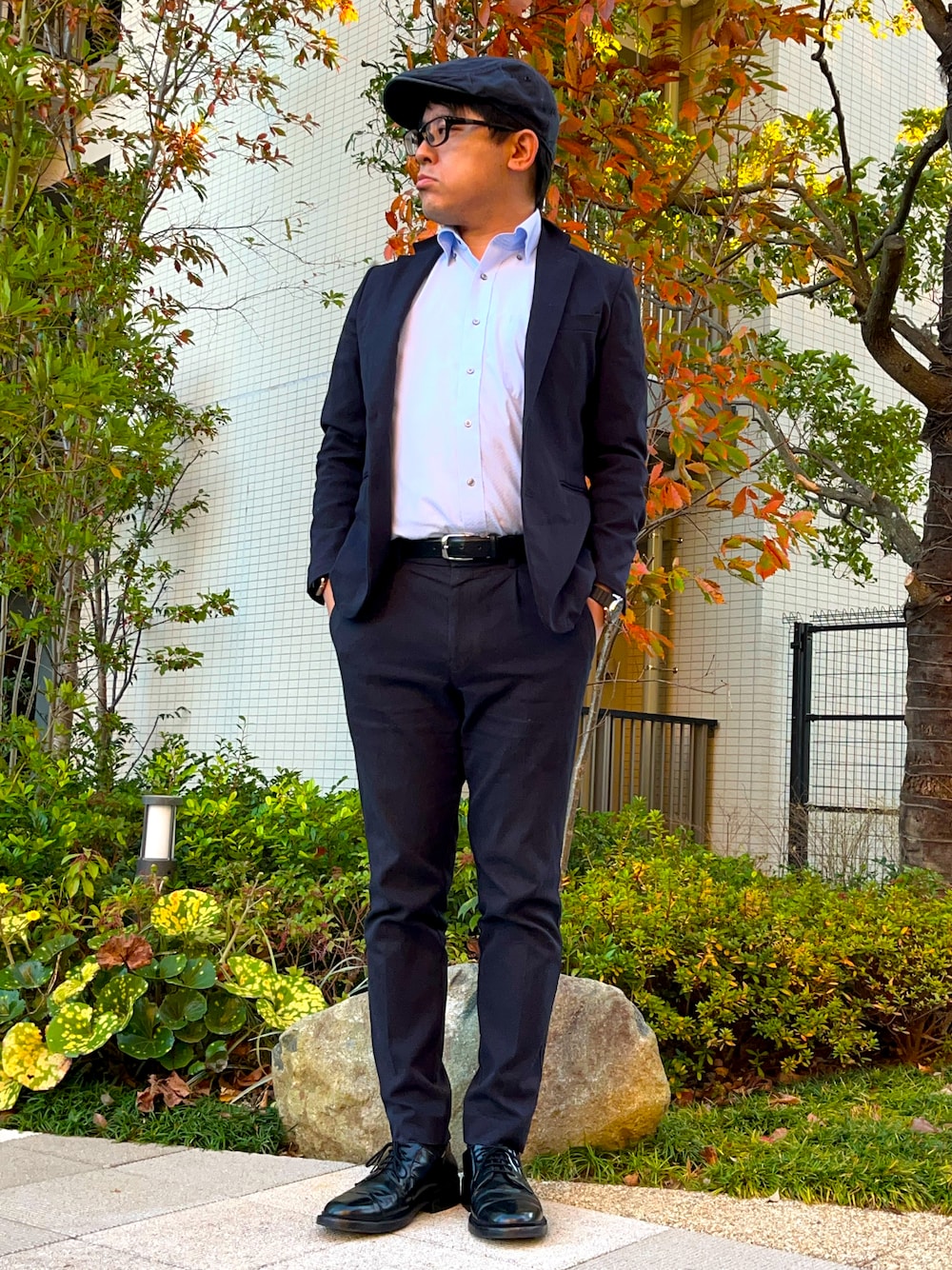 ブラック系のドレスシューズ、ピンク系のビジネスシャツ、ブルー系のセットアップを着用したメンズの冬コーディネートの1枚目の写真