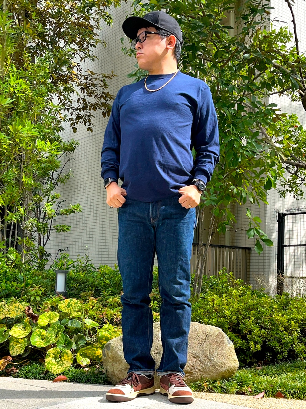 ブルー系のTシャツ/カットソー、ブルー系のデニムパンツ、ブラウン系のスニーカーを着用したメンズの秋コーディネートの1枚目の写真