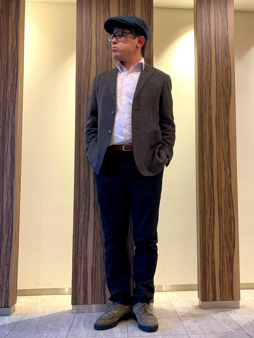 ピンク系のビジネスシャツ、ブラウン系のテーラードジャケット、ブラック系のチノパンツを着用したメンズの冬コーディネートの1枚目の写真