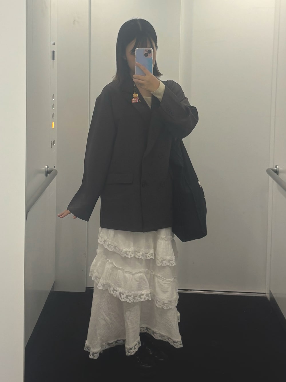 ブラウン系のテーラードジャケット、ホワイト系のスカートを着用したレディースの秋コーディネートの1枚目の写真