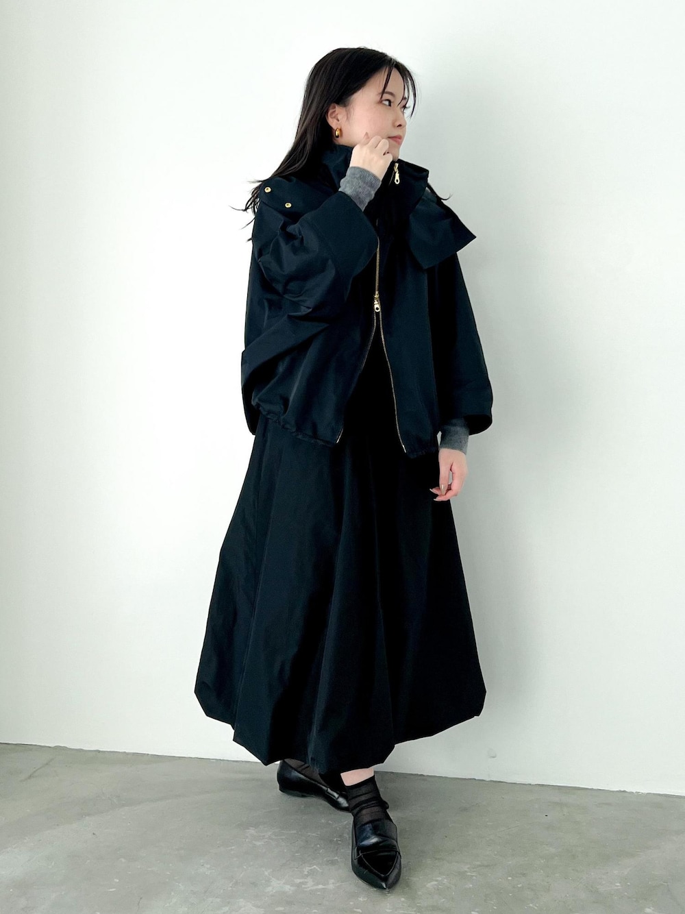 グレー系のニット/セーター、ブルー系のマウンテンパーカー、ブラック系のパンプスを着用したレディースの冬コーディネートの1枚目の写真