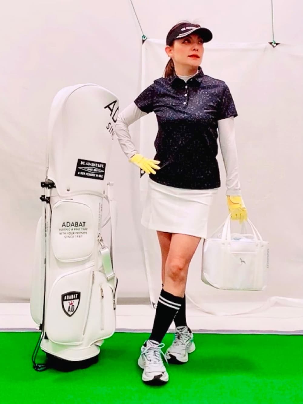 「春のNewスタイル、アウトドアスタイル、大人カジュアル、スポーツミックス、トートバッグ、保冷バッグ、ゴルフ、ゴルフウェア、レイヤードスタイル、紫外線対策、スカート×スニーカー、スリットスカート、バティック柄、モノトーンコーデ、接触冷感」｜「adabatのメッセージロゴサンバイザー（サンバイザー、ブラック系）」を使った、lennie12さん（骨格ウェーブ・レディース・162cm）の春コーディネートの1枚目の写真