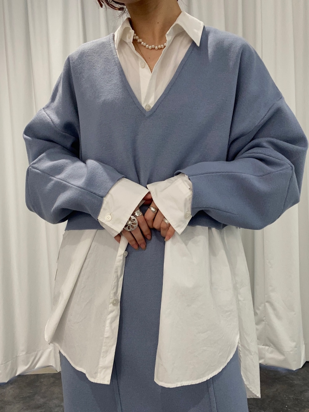 ブルー系のスカート、ブルー系のニット/セーター、ブラック系のパンプスを着用したレディースの冬コーディネートの2枚目の写真