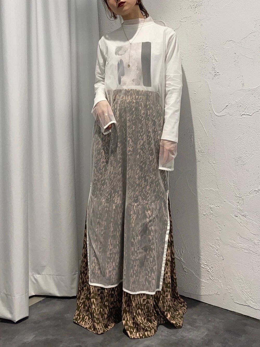 グリーン系のスカート、ホワイト系のワンピース、ホワイト系のTシャツ/カットソーを着用したレディースの冬コーディネートの1枚目の写真