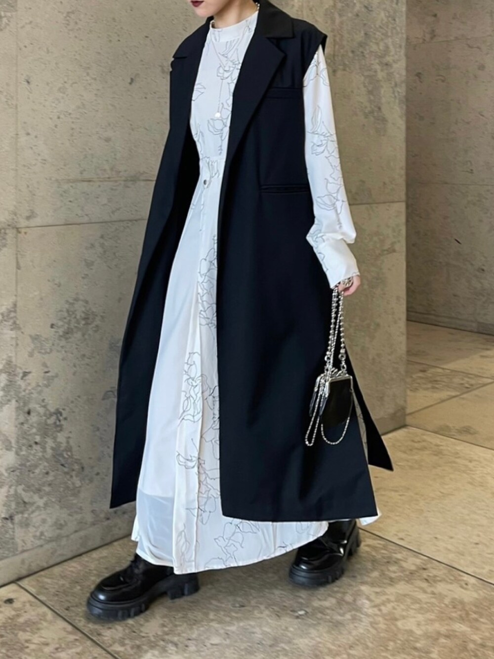 ホワイト系のワンピース、ブラック系のベスト、ブラック系のその他を着用したレディースの冬コーディネートの2枚目の写真