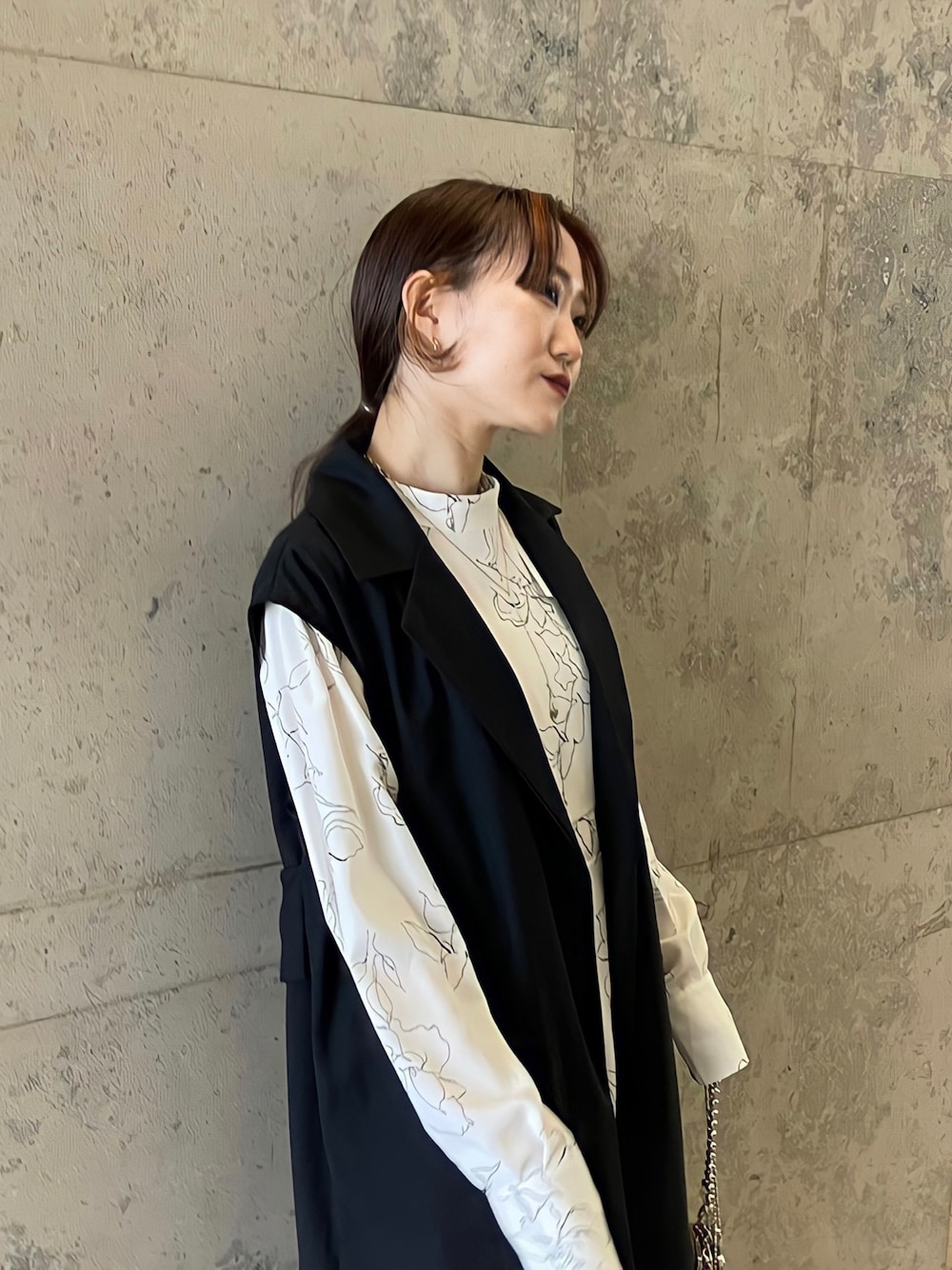 ホワイト系のワンピース、ブラック系のベスト、ブラック系のその他を着用したレディースの冬コーディネートの3枚目の写真