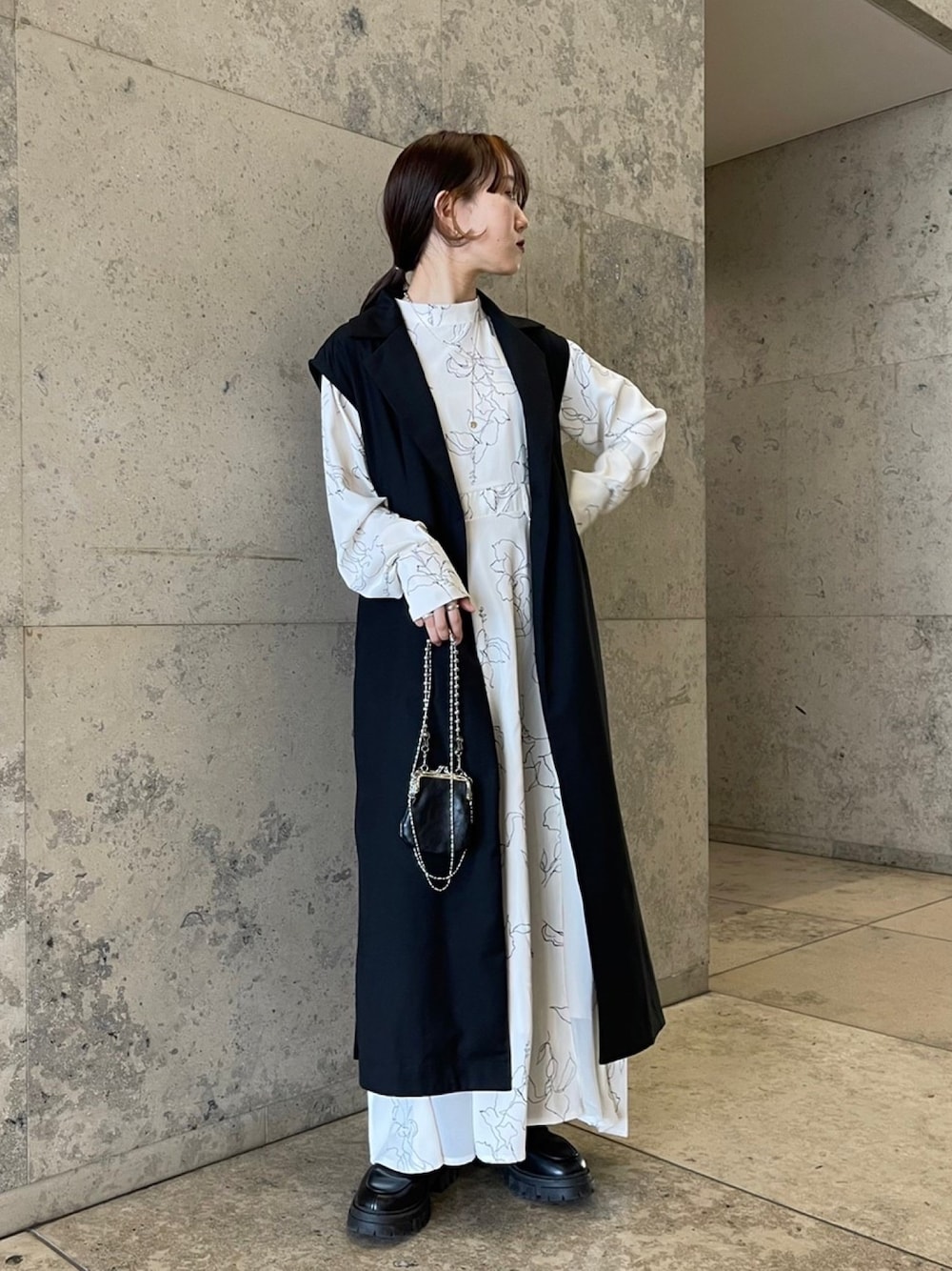 ホワイト系のワンピース、ブラック系のベスト、ブラック系のその他を着用したレディースの冬コーディネートの4枚目の写真