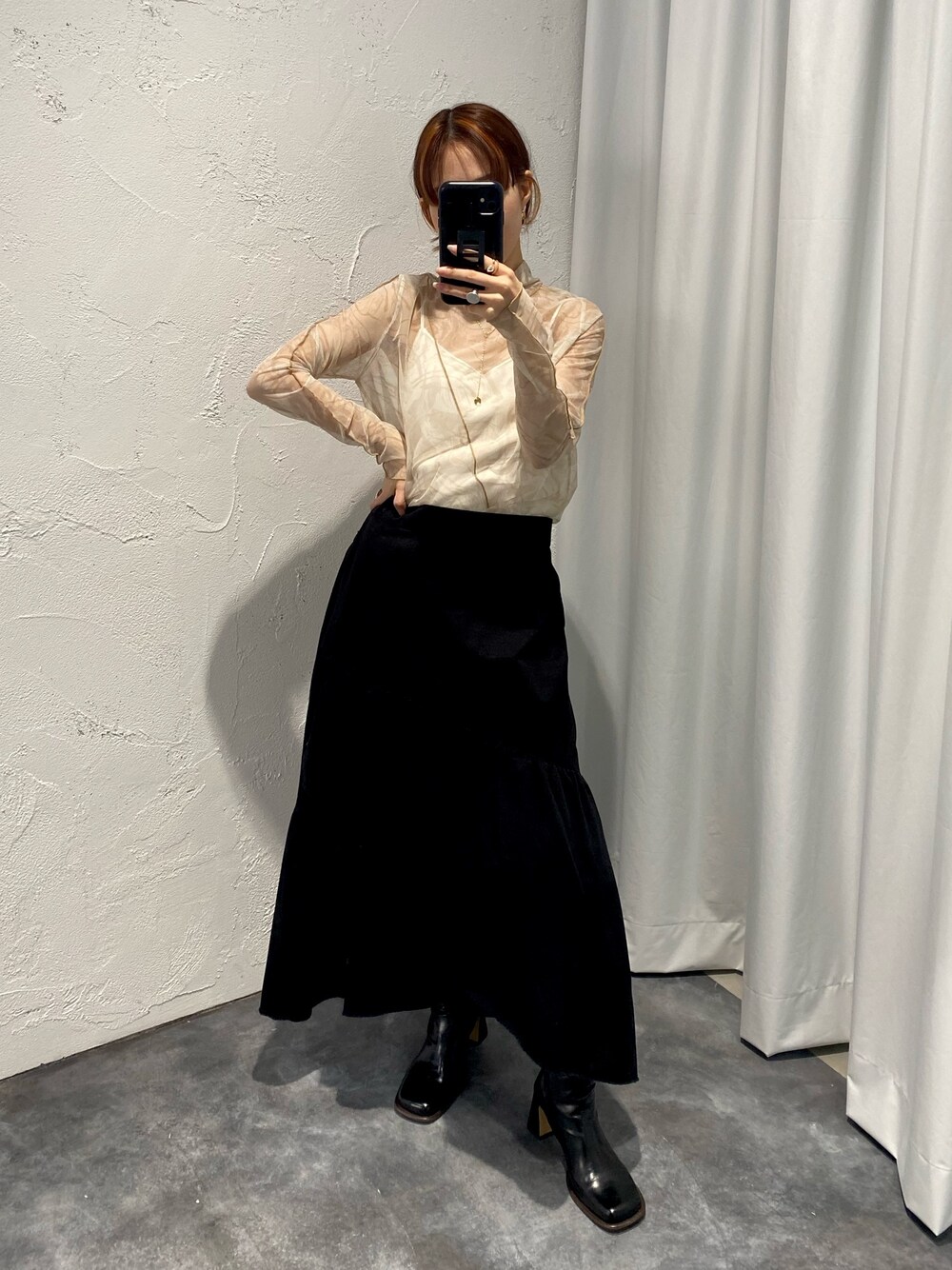 ホワイト系のTシャツ/カットソー、ホワイト系のキャミソール、ブラック系のスカートを着用したレディースの冬コーディネートの3枚目の写真