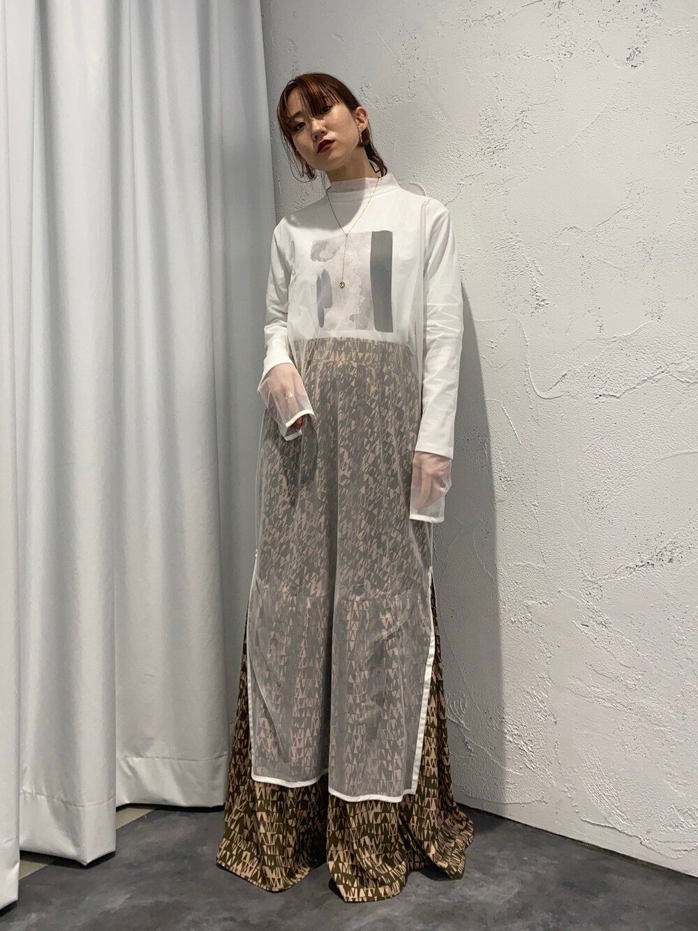 グリーン系のスカート、ホワイト系のワンピース、ホワイト系のTシャツ/カットソーを着用したレディースの冬コーディネートの2枚目の写真