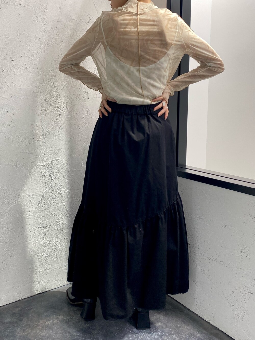 ホワイト系のTシャツ/カットソー、ホワイト系のキャミソール、ブラック系のスカートを着用したレディースの冬コーディネートの2枚目の写真