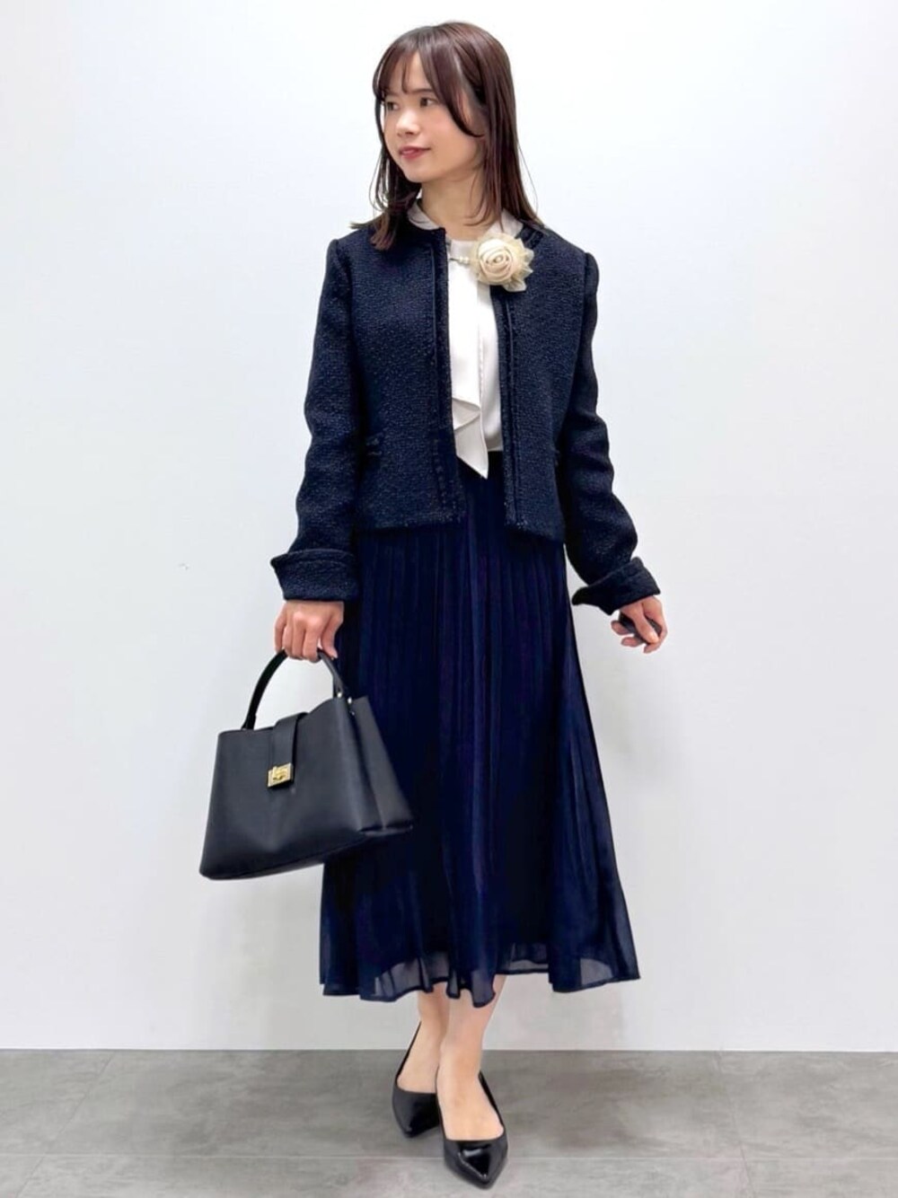 ブルー系のノーカラージャケット、ベージュ系のシャツ/ブラウス、ブルー系のスカートを着用したレディースの春コーディネートの1枚目の写真
