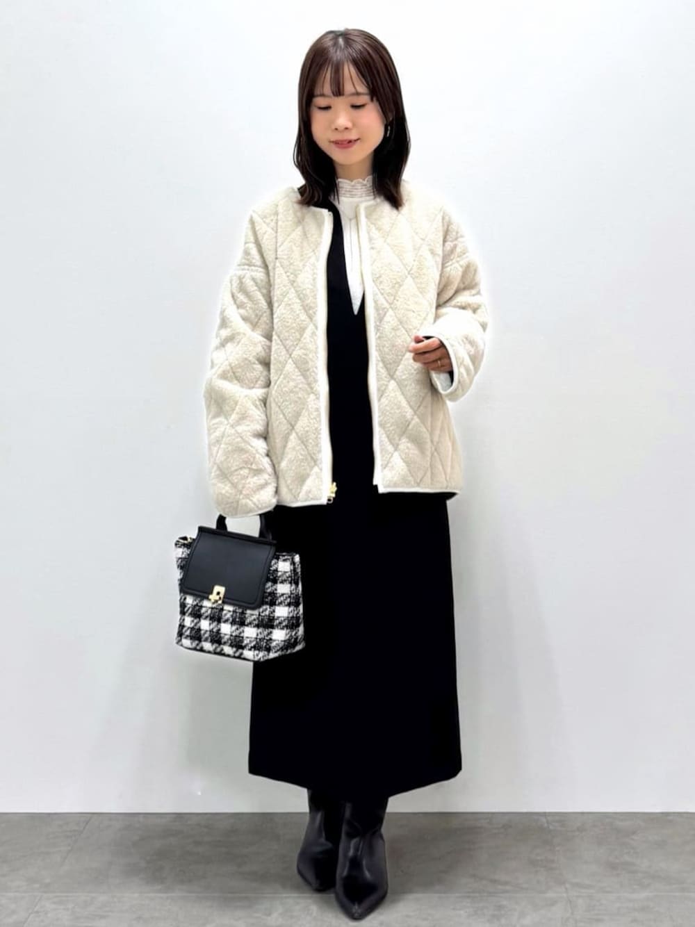 ブラック系のワンピース、ホワイト系のシャツ/ブラウス、ブラック系のハンドバッグを着用したレディースの冬コーディネートの1枚目の写真