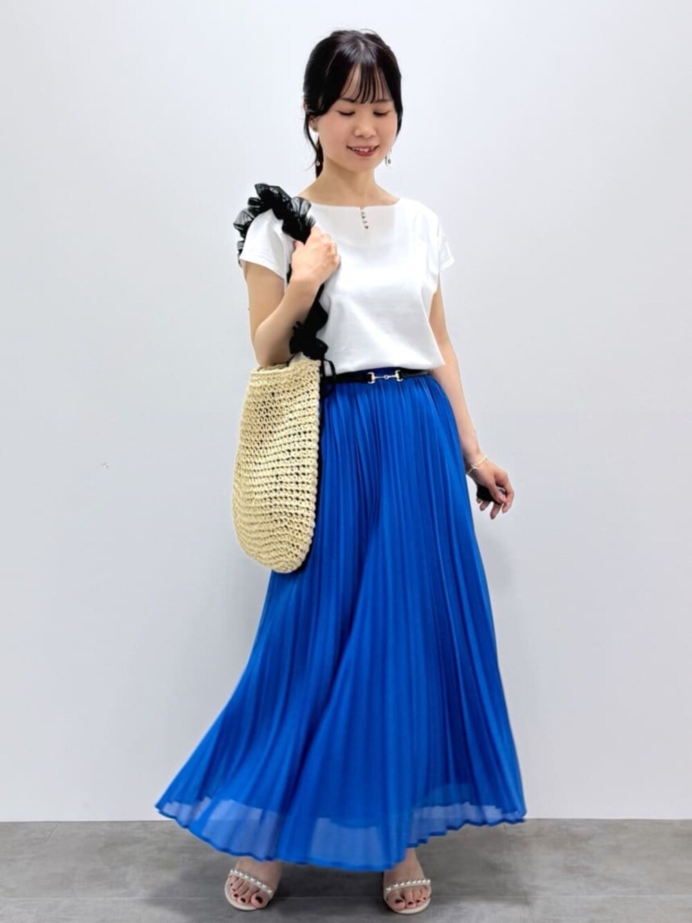 ホワイト系のTシャツ/カットソー、ブルー系のスカート、ベージュ系のトートバッグを着用したレディースの春コーディネートの1枚目の写真