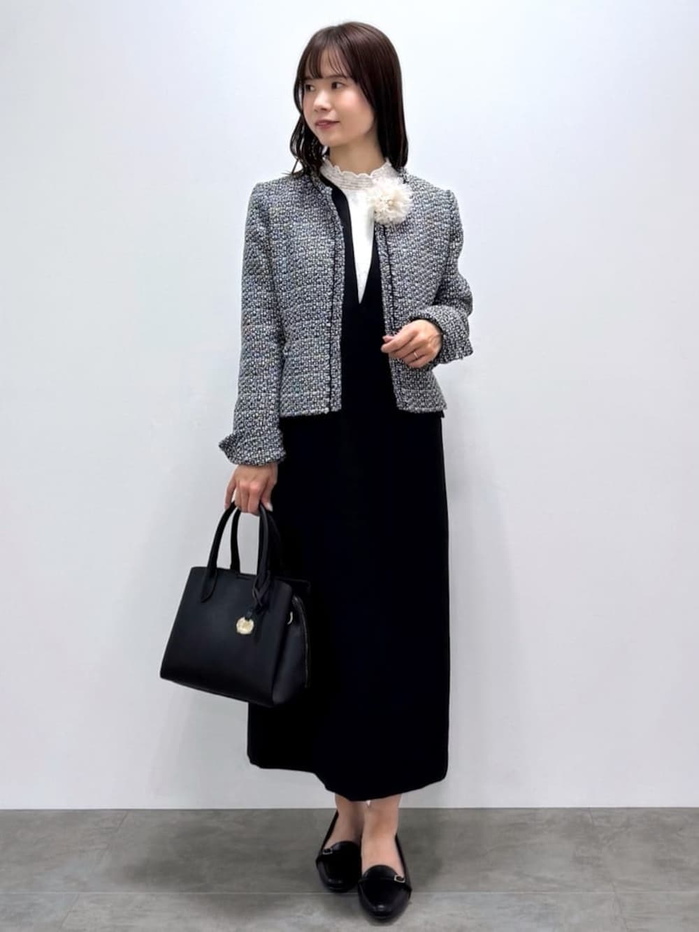 ブラック系のノーカラージャケット、ブラック系のワンピース、ホワイト系のシャツ/ブラウスを着用したレディースの冬コーディネートの1枚目の写真