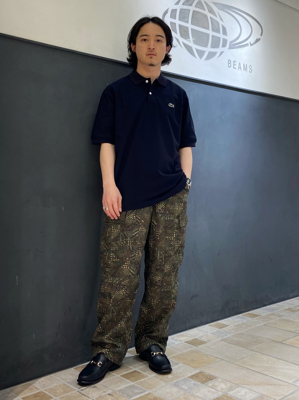 ブルー系のポロシャツ、グリーン系のカーゴパンツ、ブラック系のローファーを着用したメンズの夏コーディネートの1枚目の写真