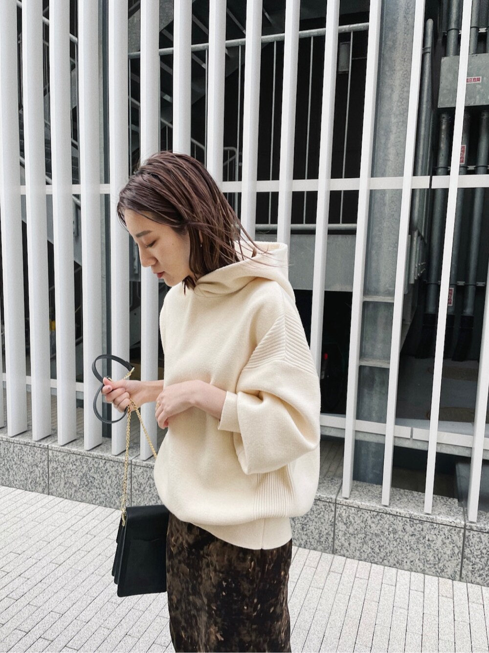 ブラウン系のスカート、ホワイト系のパーカーを着用したレディースの冬コーディネートの1枚目の写真