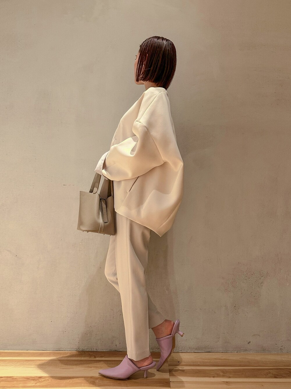 グレー系のその他パンツ、ベージュ系のハンドバッグ、ブラウン系のノーカラーコートを着用したレディースの冬コーディネートの1枚目の写真