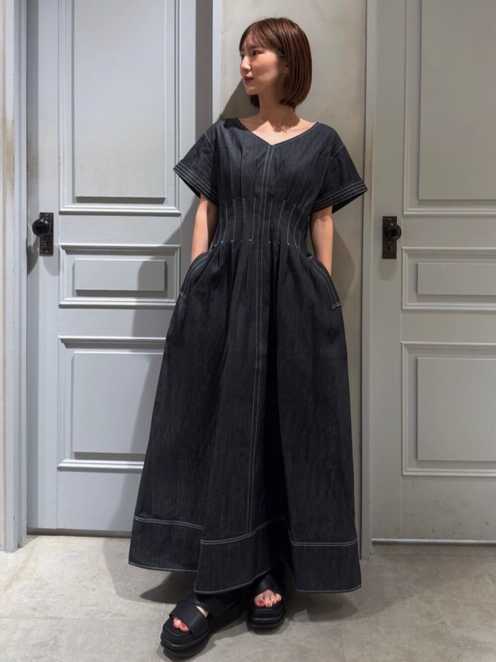 ブルー系のワンピース、ブラック系のサンダルを着用したレディースの春コーディネートの1枚目の写真