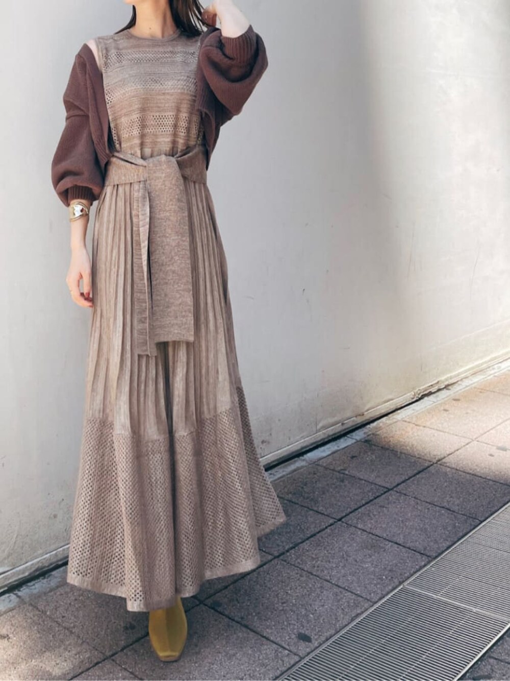 ブラウン系のカーディガン/ボレロ、ベージュ系のワンピース、イエロー系のスリッポンを着用したレディースの夏コーディネートの1枚目の写真