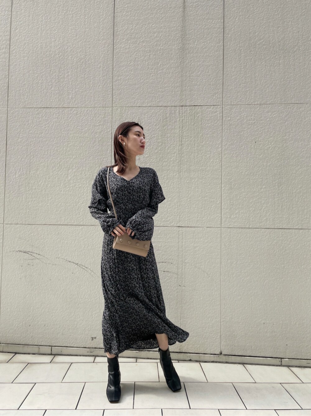 ベージュ系のハンドバッグ、ブラック系のワンピースを着用したレディースの冬コーディネートの1枚目の写真