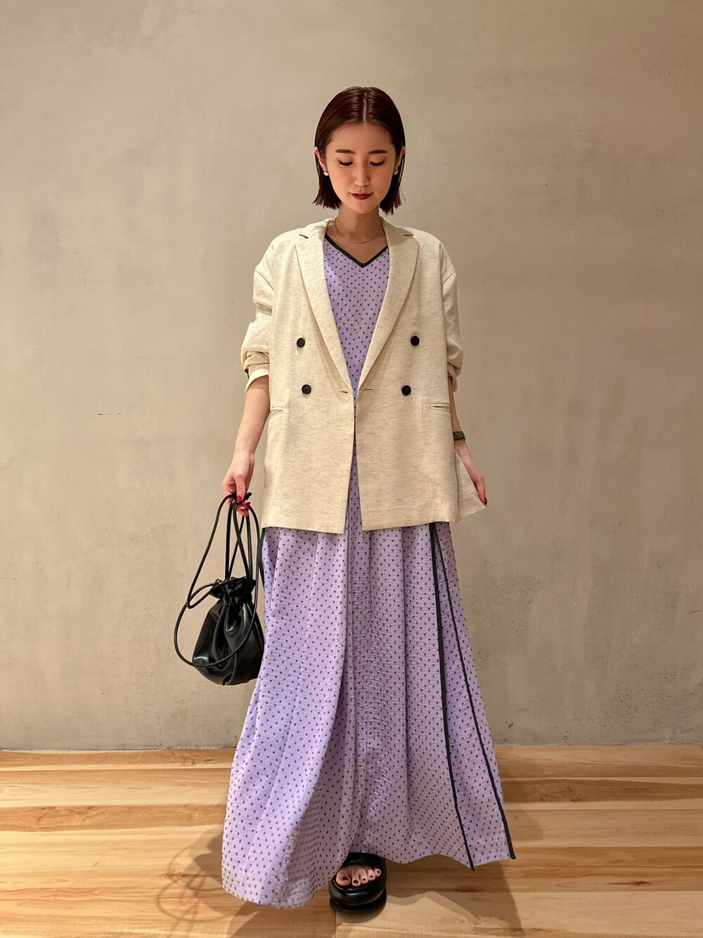 パープル系のワンピース、ベージュ系のテーラードジャケット、ブラック系のサンダルを着用したレディースの冬コーディネートの1枚目の写真