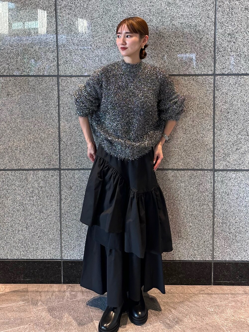 ブラック系のニット/セーター、ブラック系のスカートを着用したレディースの秋コーディネートの1枚目の写真