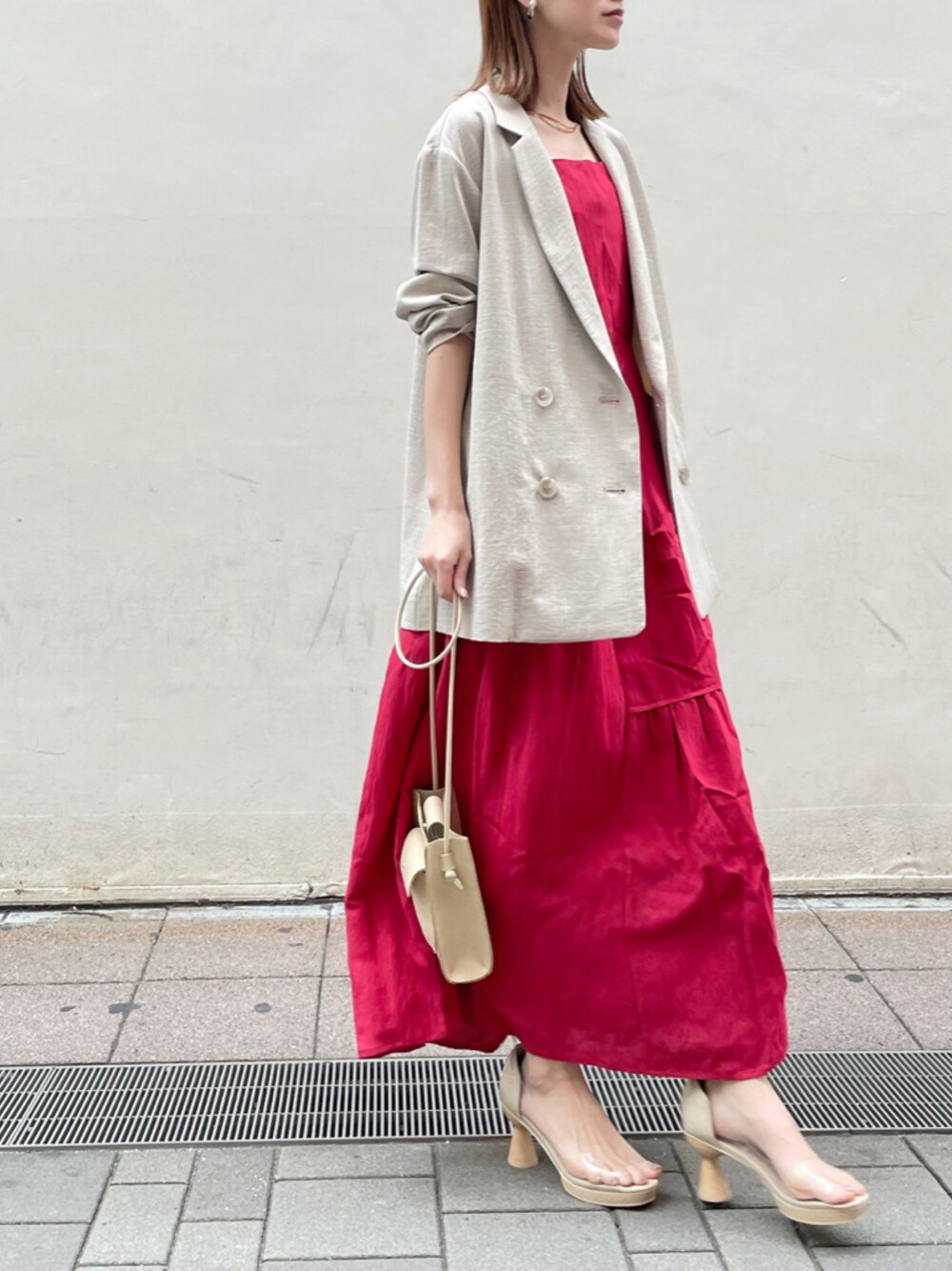 その他のパンプス、レッド系のワンピース、ベージュ系のテーラードジャケットを着用したレディースの春コーディネートの1枚目の写真