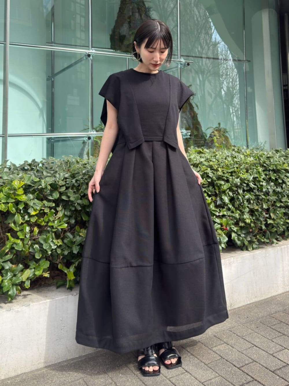ブラック系のワンピースを着用したレディースの春コーディネートの1枚目の写真