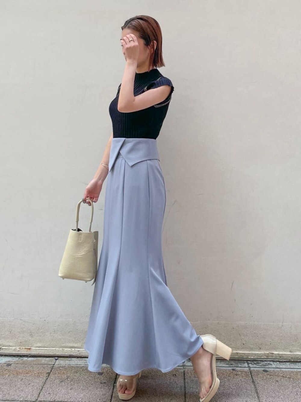 ブルー系のスカート、ブラック系のニット/セーターを着用したレディースの夏コーディネートの1枚目の写真