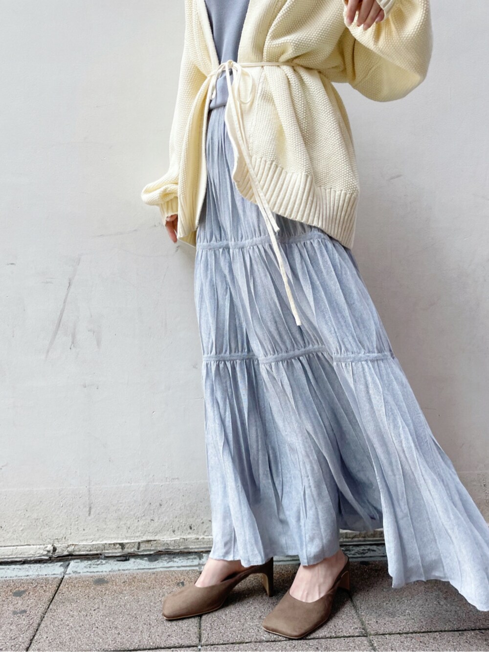 ベージュ系のサンダル、ホワイト系のカーディガン/ボレロ、ブルー系のワンピースを着用したレディースの春コーディネートの1枚目の写真