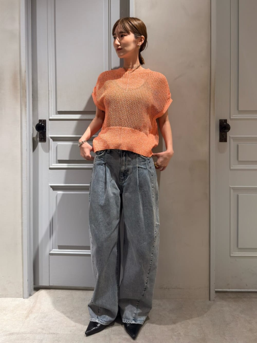 ブルー系のデニムパンツ、ピンク系のニット/セーターを着用したレディースの春コーディネートの1枚目の写真