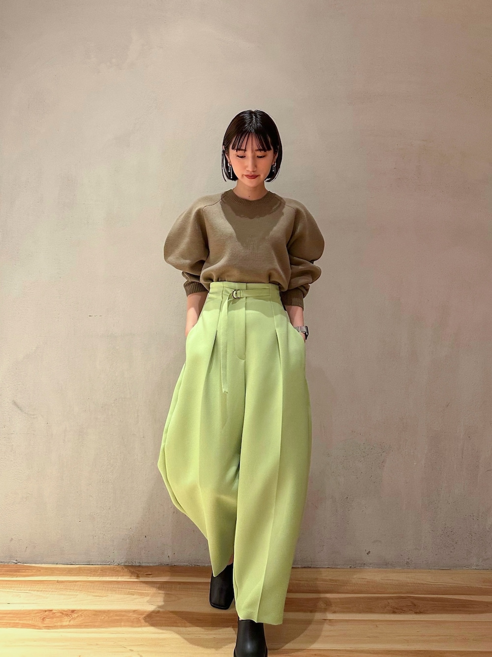 グリーン系のその他パンツ、ベージュ系のニット/セーター、ブラック系のブーティを着用したレディースの冬コーディネートの1枚目の写真