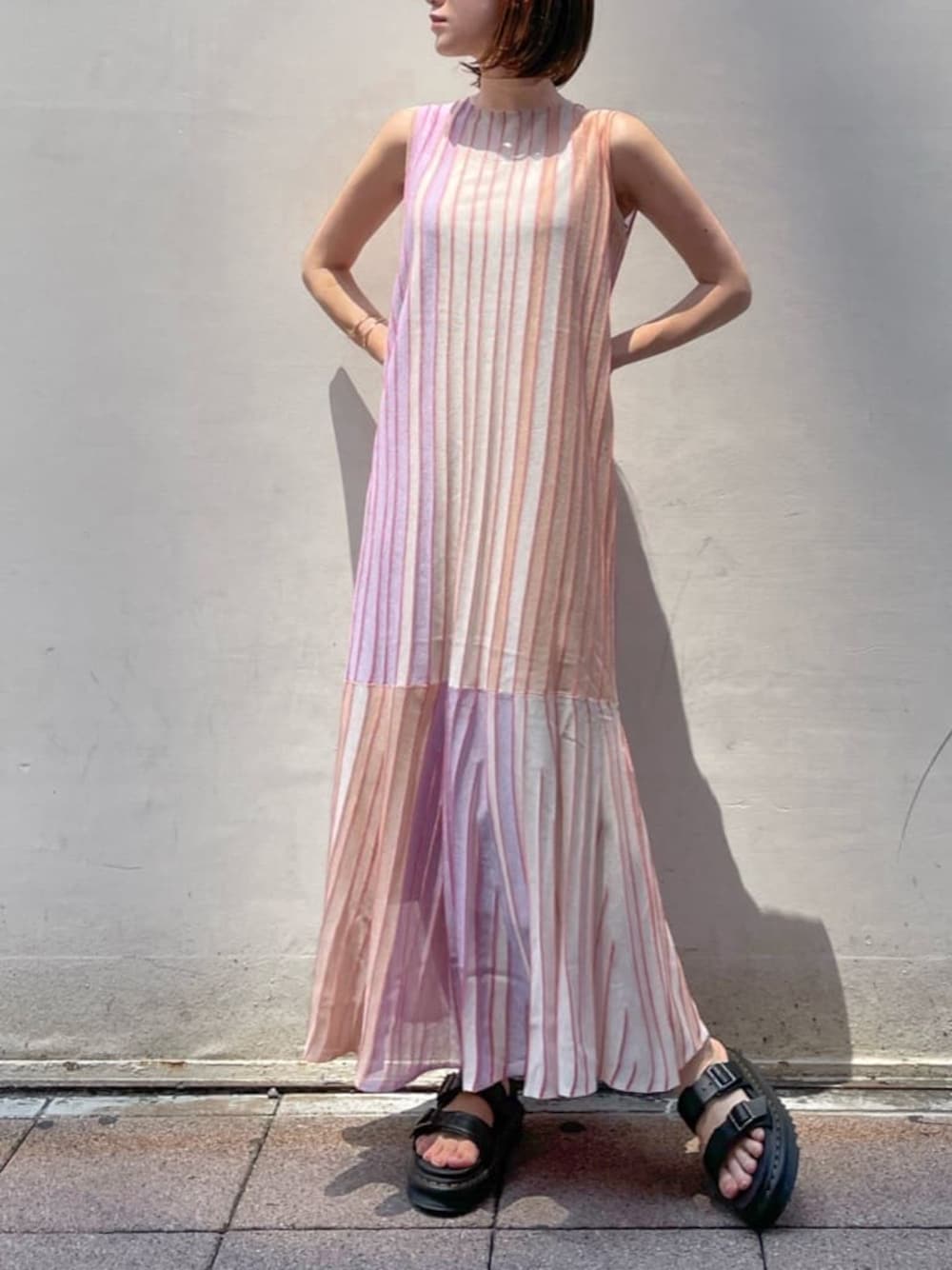 オレンジ系のワンピース、ブラック系のその他シューズを着用したレディースの夏コーディネートの1枚目の写真