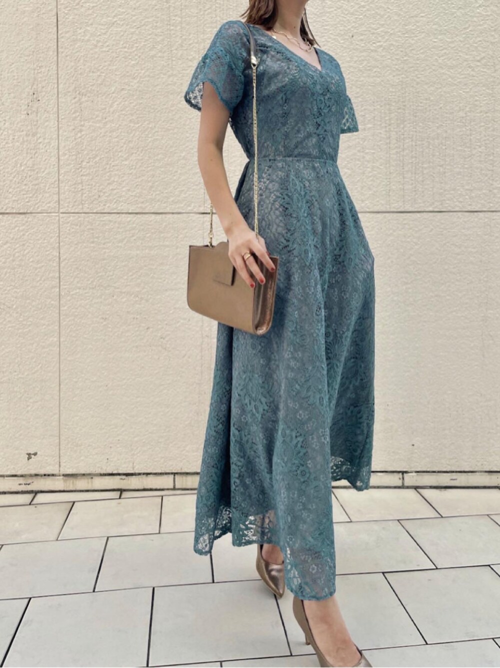 ゴールド系のハンドバッグ、ブルー系のドレス、ゴールド系のネックレスを着用したレディースの夏コーディネートの1枚目の写真