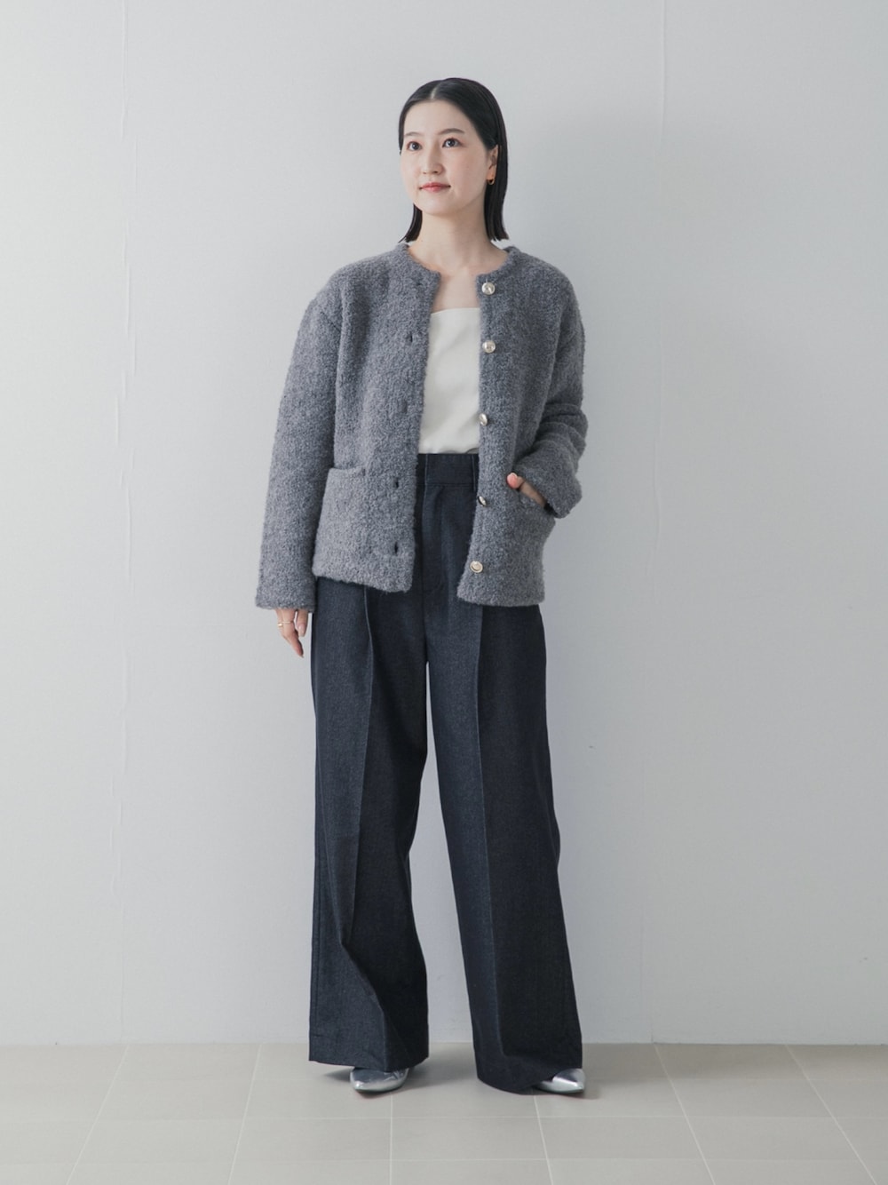 ブルー系のデニムパンツ、シルバー系のパンプス、グレー系のノーカラージャケットを着用したレディースの秋コーディネートの1枚目の写真