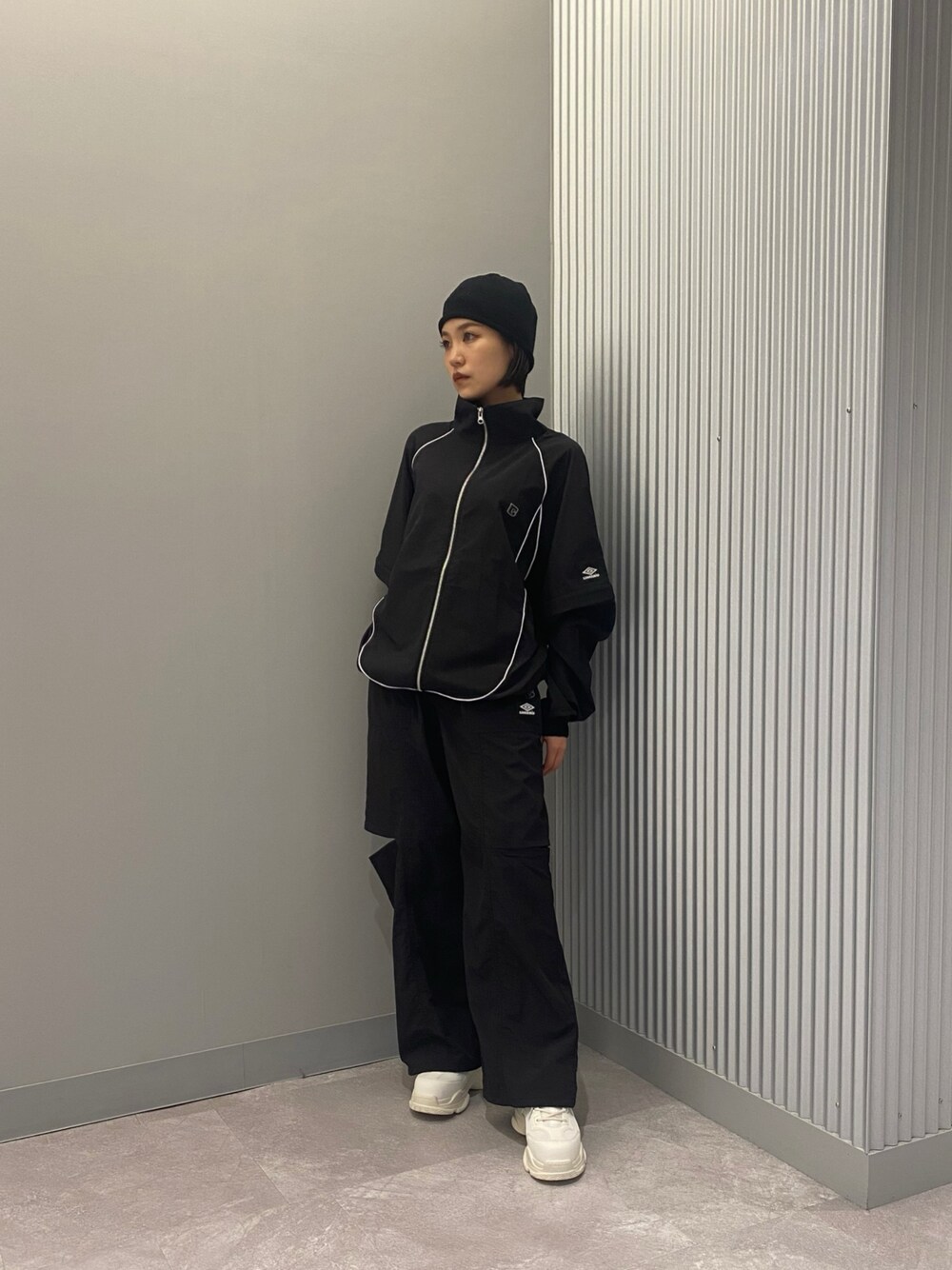 ホワイト系のスニーカー、ブラック系のその他パンツ、ブラック系のブルゾンを着用したレディースの春コーディネートの1枚目の写真