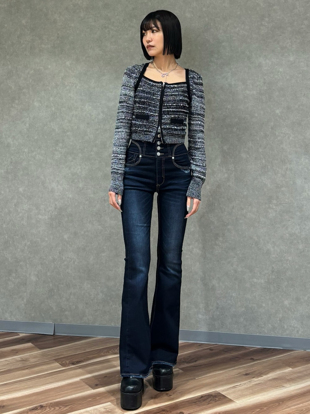 ブルー系のデニムパンツ、ブラック系のニット/セーター、ブラック系のブーツを着用したレディースの冬コーディネートの1枚目の写真