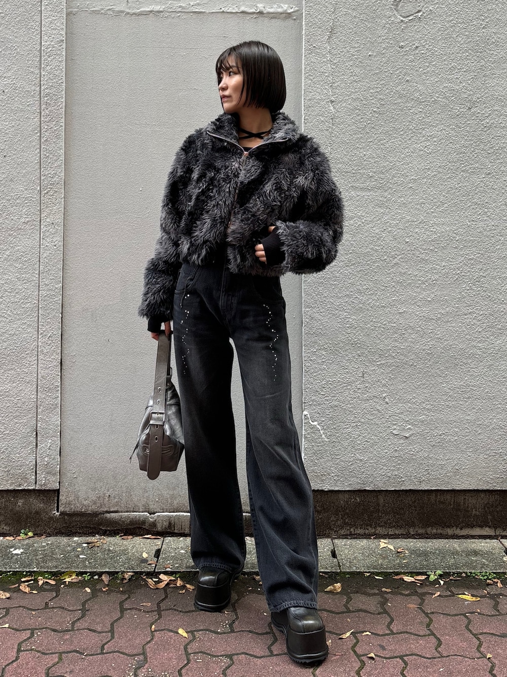 ブラック系のニット/セーター、ブラック系のデニムパンツ、その他のブルゾンを着用したレディースの秋コーディネートの1枚目の写真