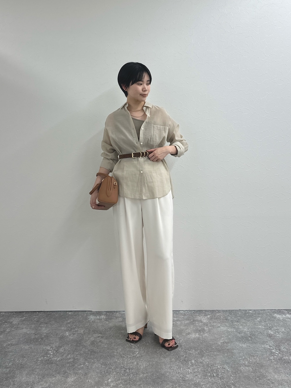 ベージュ系のシャツ/ブラウス、ホワイト系のその他パンツ、ブラウン系のボストンバッグを着用したレディースの春コーディネートの1枚目の写真