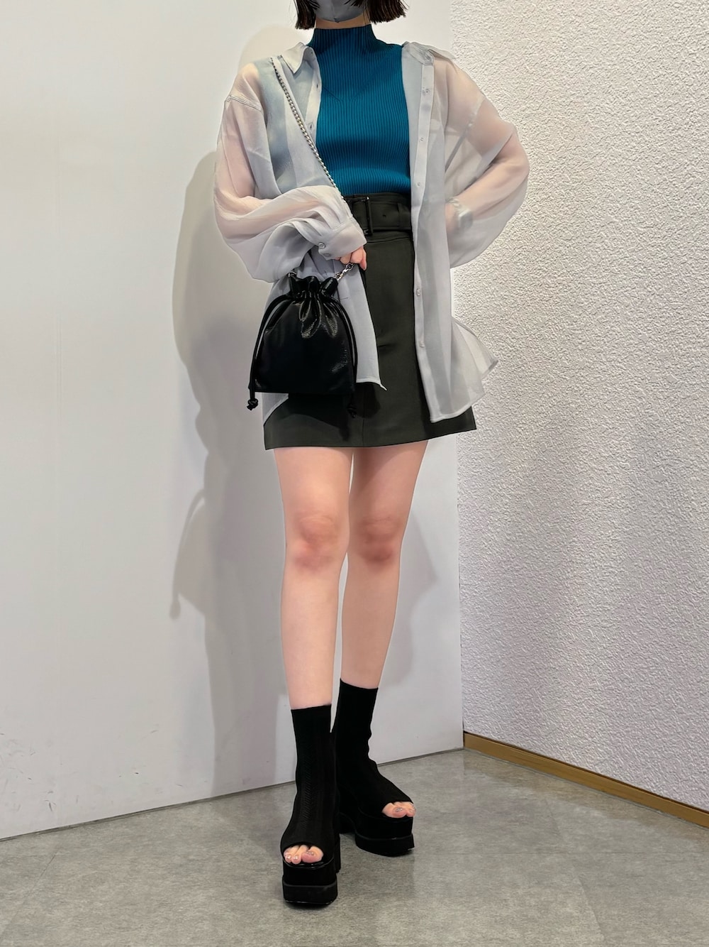 グレー系のスカート、ブラック系のショルダーバッグ、グレー系のシャツ/ブラウスを着用したレディースの春コーディネートの1枚目の写真