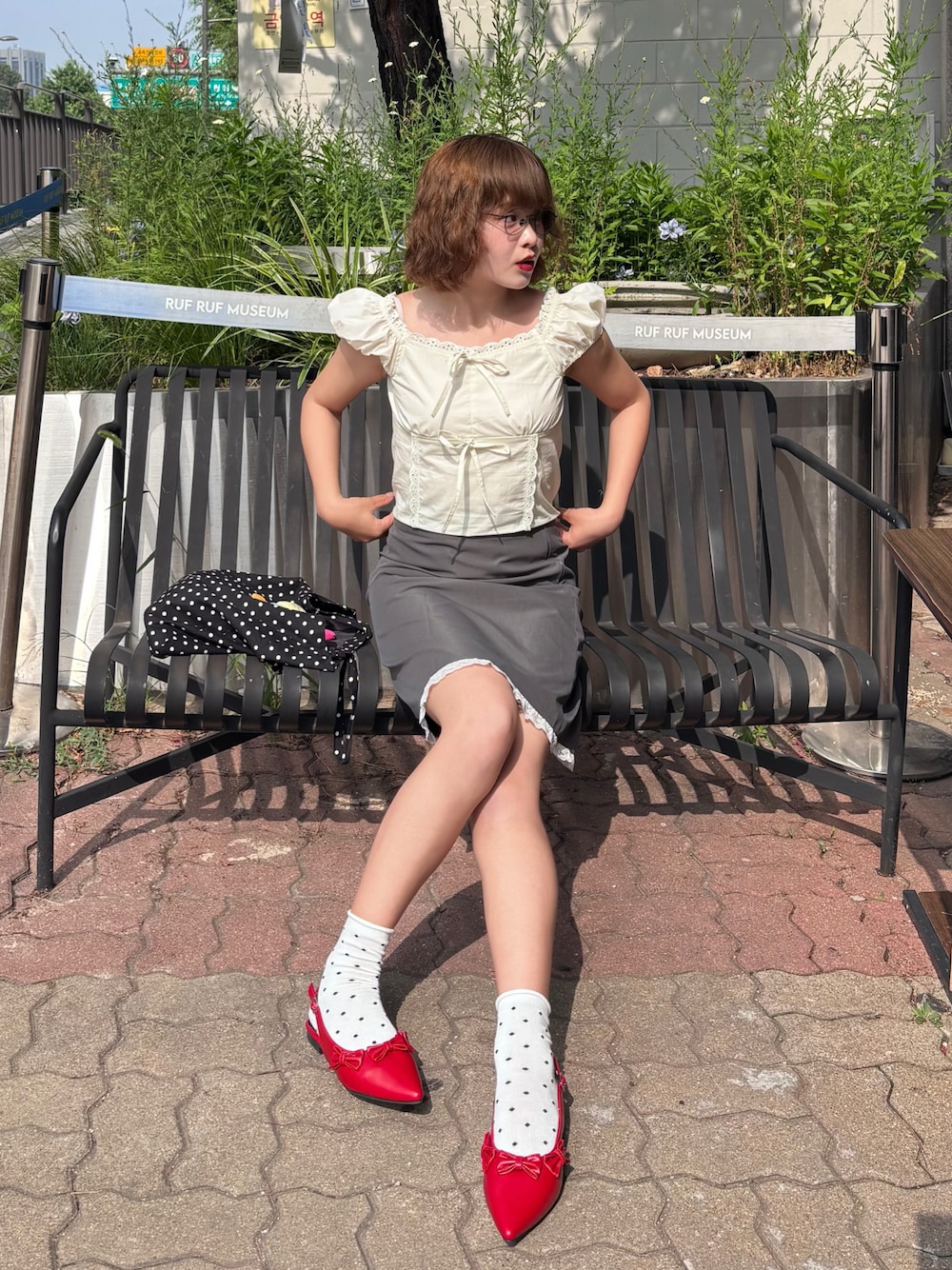ホワイト系のシャツ/ブラウス、グレー系のスカート、レッド系のパンプスを着用したレディースの夏コーディネートの1枚目の写真